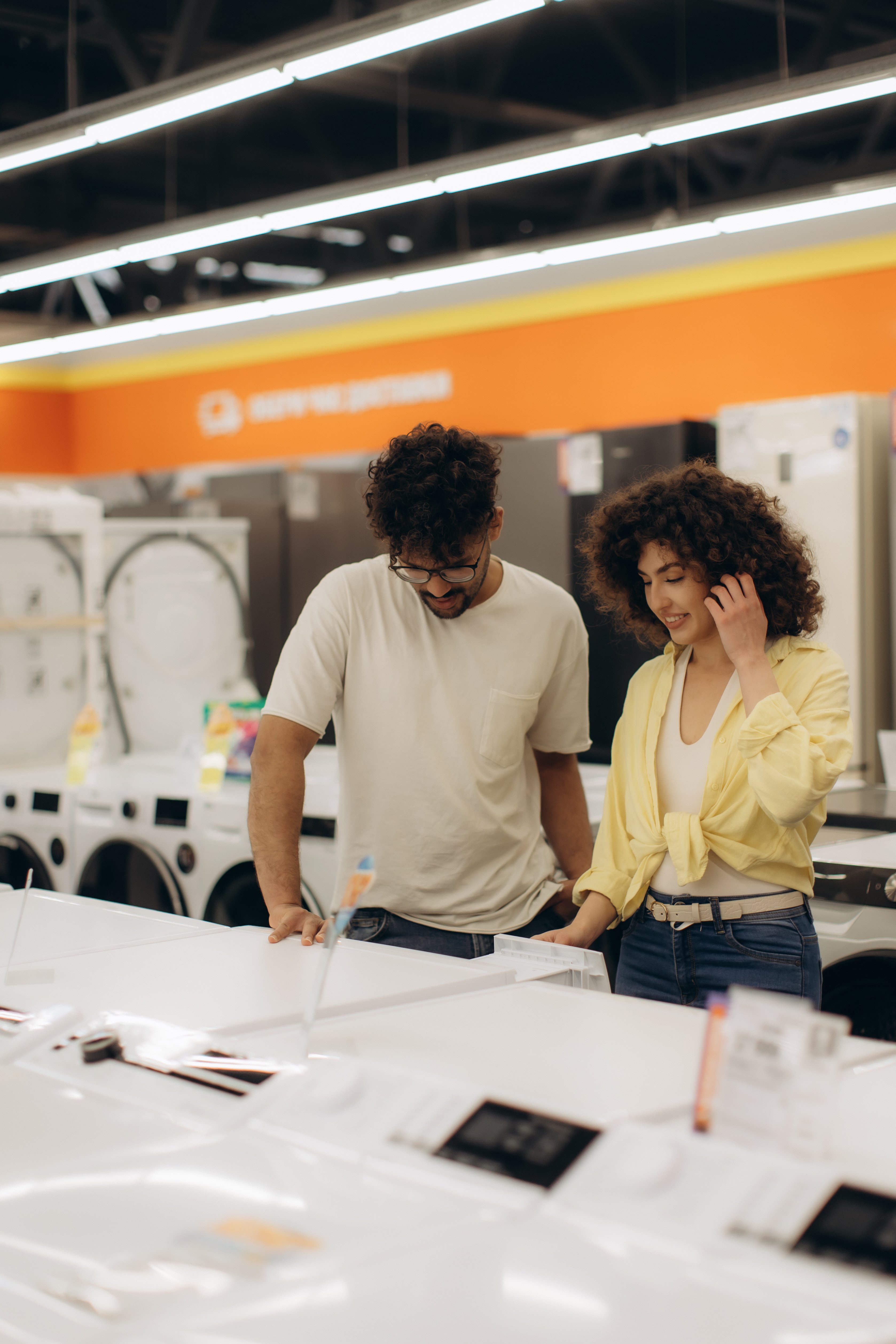 Couple buying an appliance at a store using funds from a CD Secured Loan.