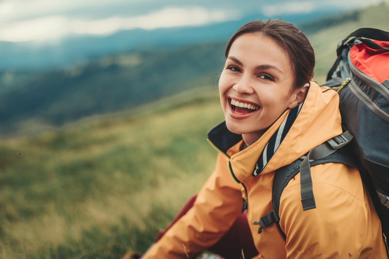 A happy woman goes hiking after opening an account with Wasatch Peaks Credit Union.
