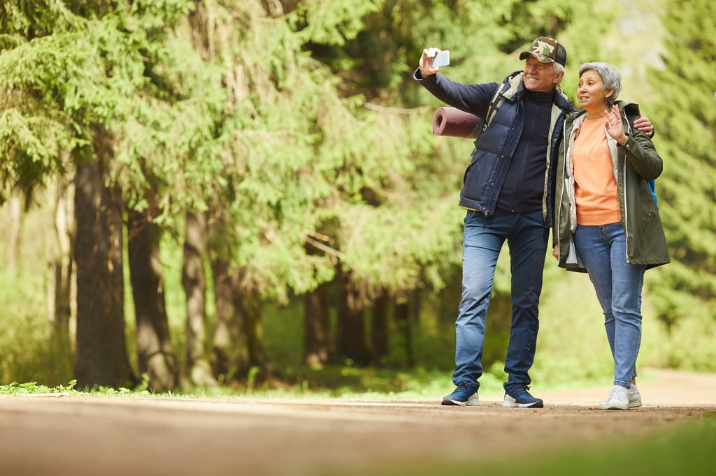 A retired couple takes a selfie while enjoying a hike on vacation thanks to the funds on their Roth IRA.