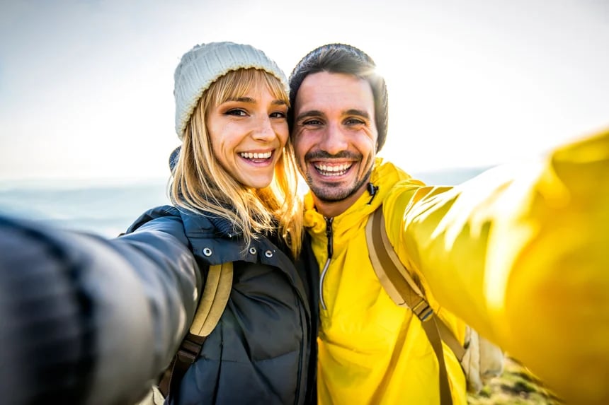 A couple celebrates after climbing a mountain in Utah.
