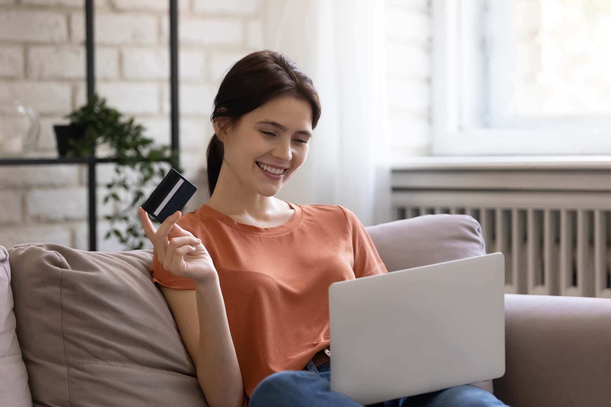 A woman smiling as she redeems points with her rewards credit card.