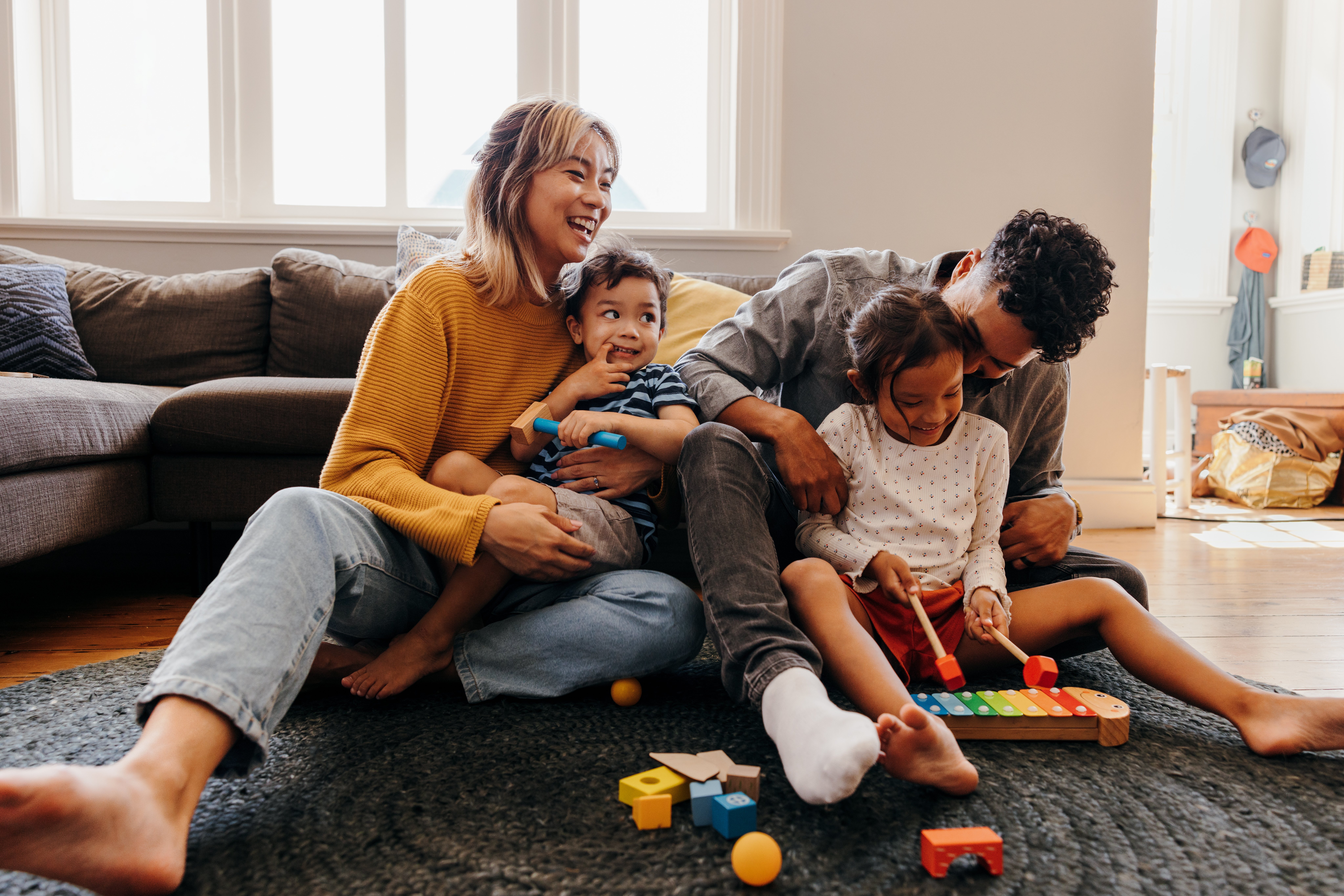 A young family relaxes at home after freeing up much-needed cash through a conventional refinance with Wasatch Peaks  Credit Union.