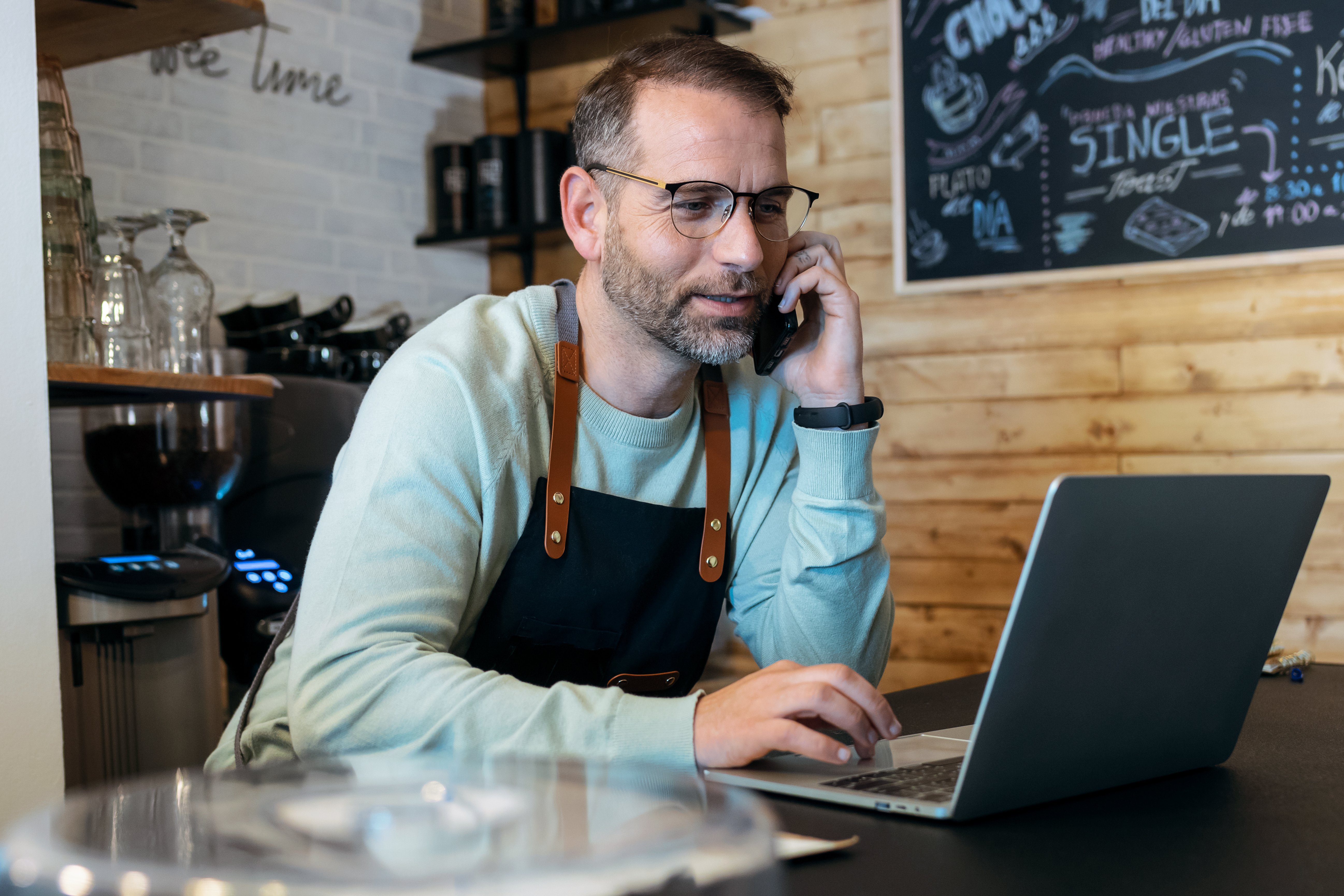 A cafe owner checks his business savings account online.