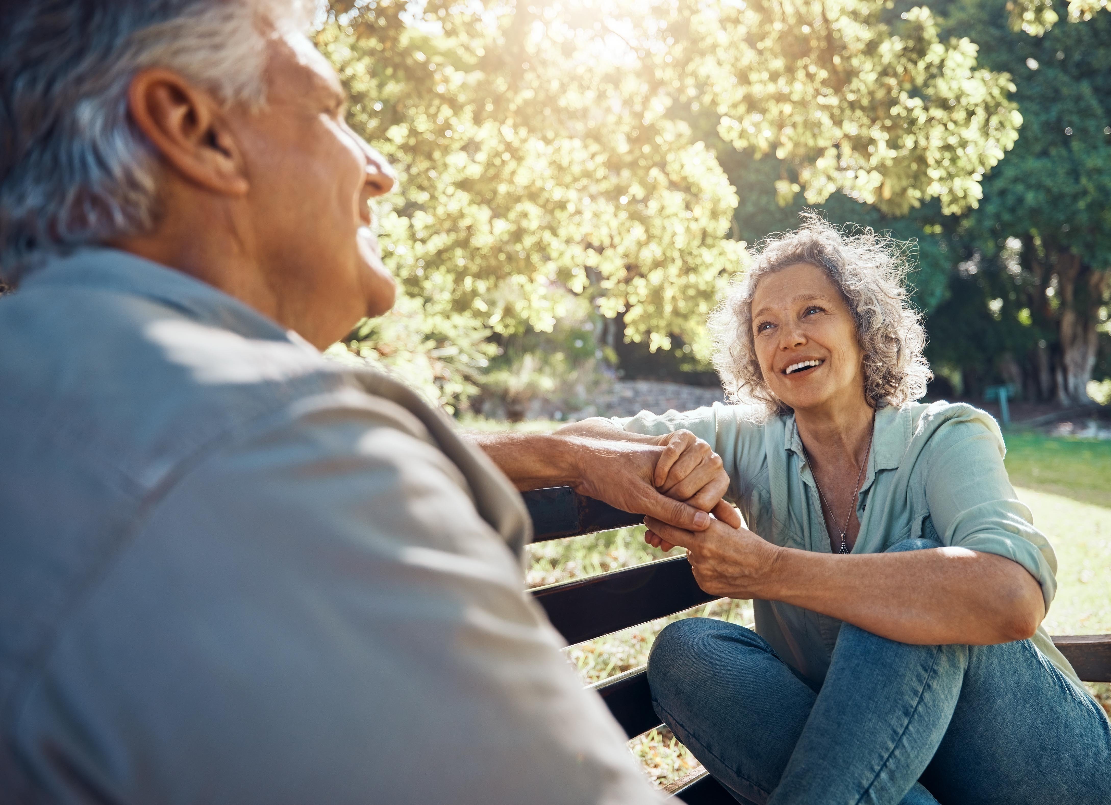 An older couple spend time together in a park, confident that their retirement savings are secure in a Traditional IRA.