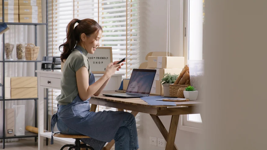  A woman using mobile banking to check the balance on her startup business checking account.
