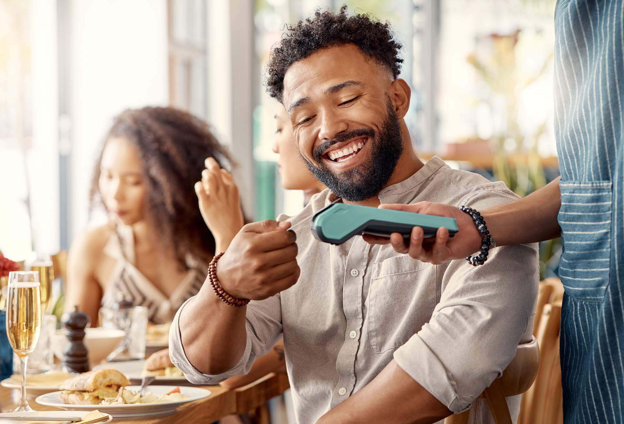A man paying for lunch with his Summit Rewards Credit Card.
