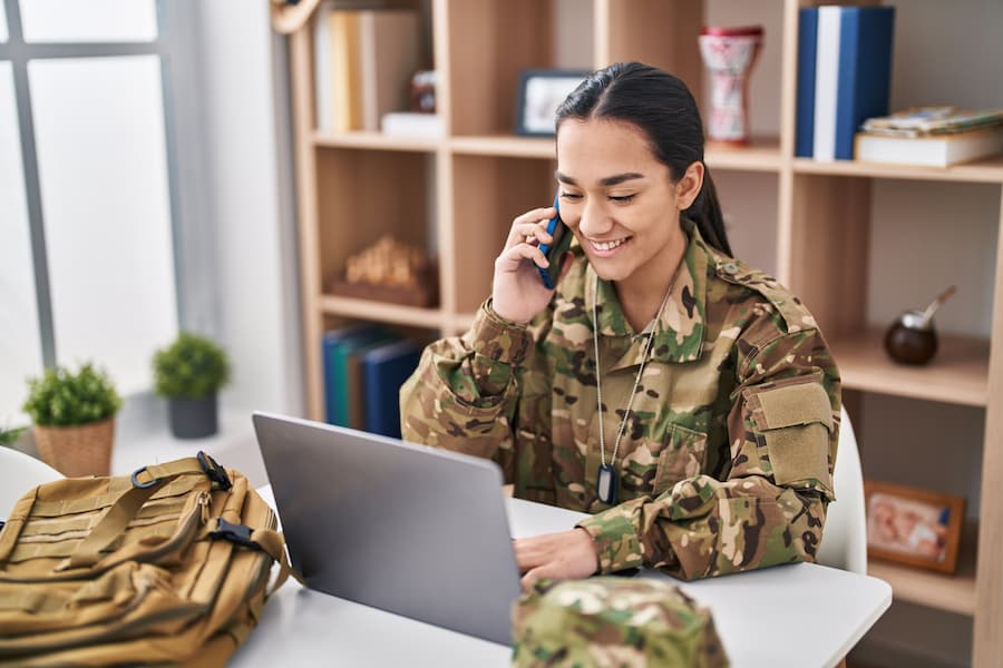 A young service member uses a laptop to apply online for a VA Home Loan
