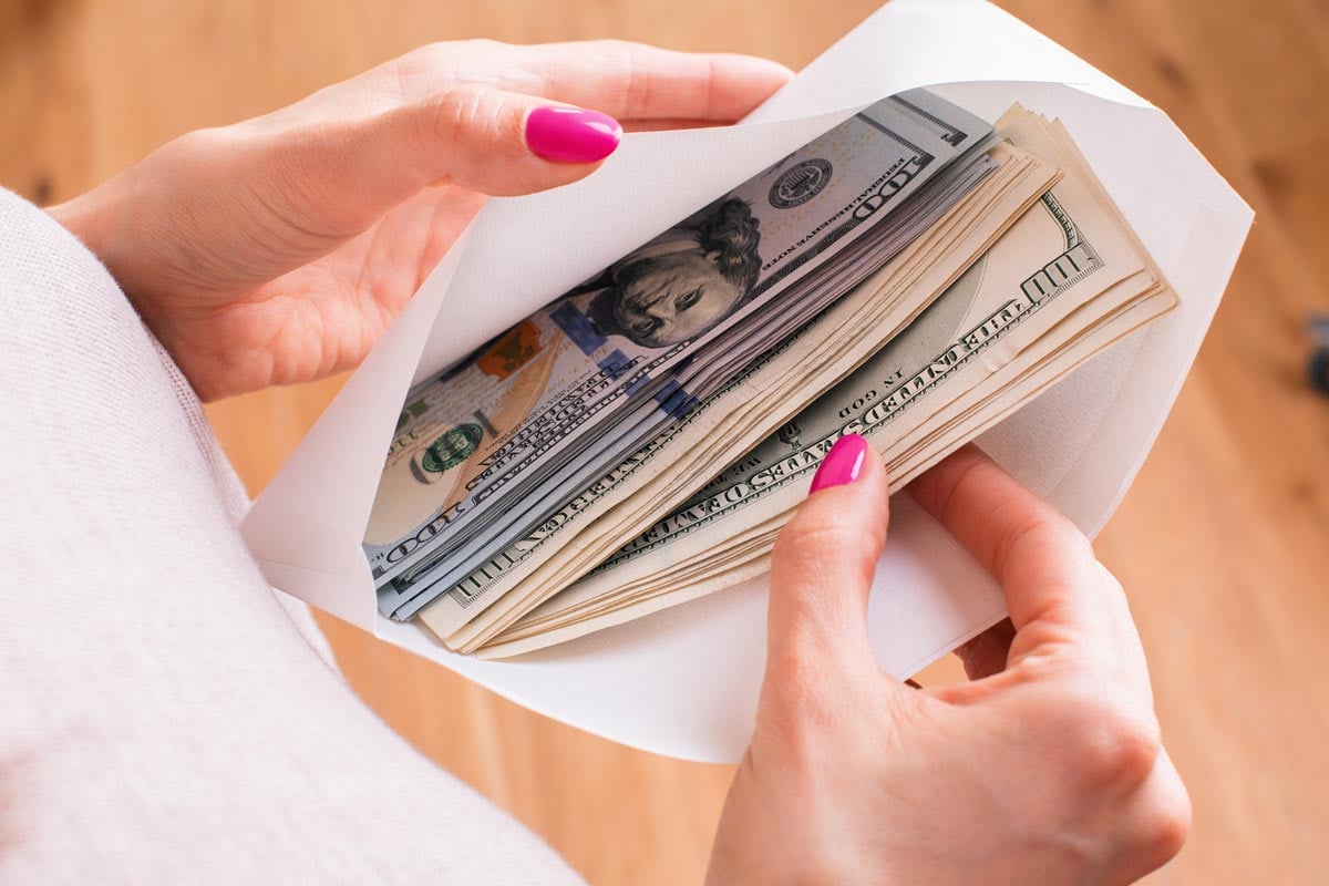 Woman holding envelope with cash inside