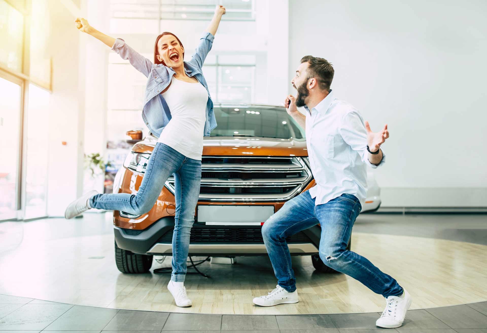 Woman and man celebrating getting a new car
