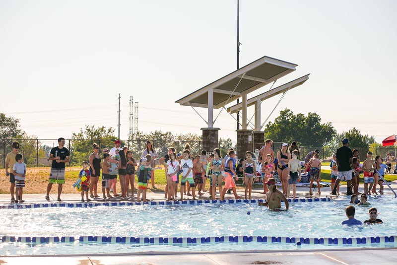 kids catching balls next to pool