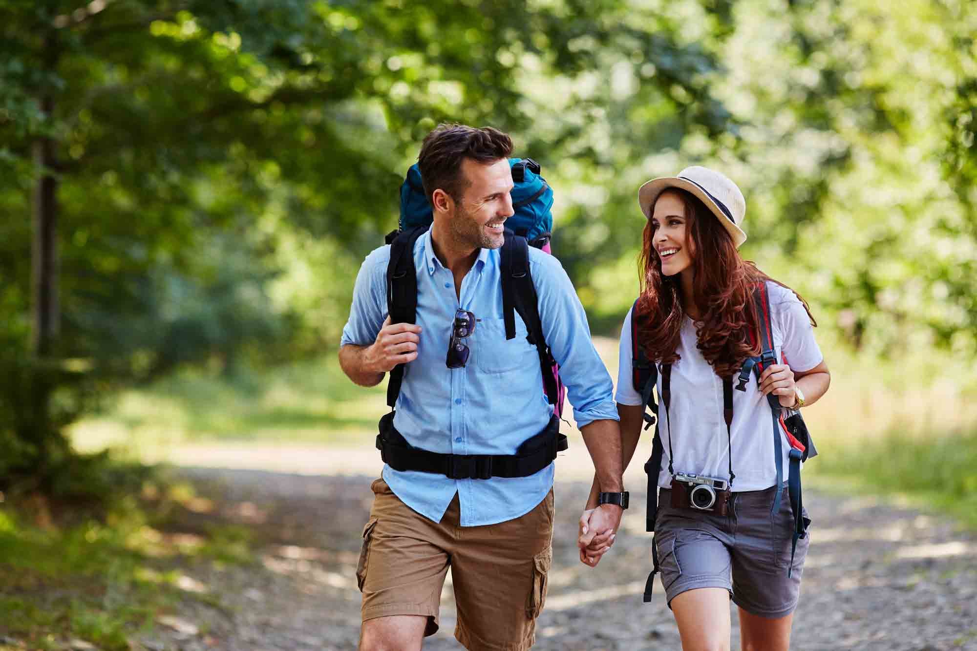 Couple hiking with backpacks enjoying rewards checking with their Peaks Perks Checking Account