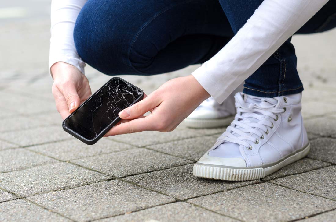 Picking up broken cellphone off ground to be fixed by phone insurance