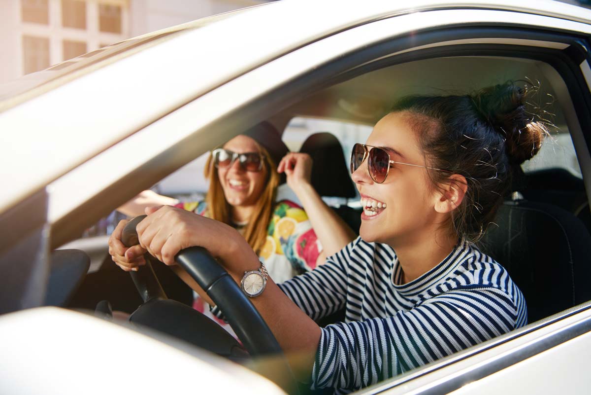 Young women smiling while driving car