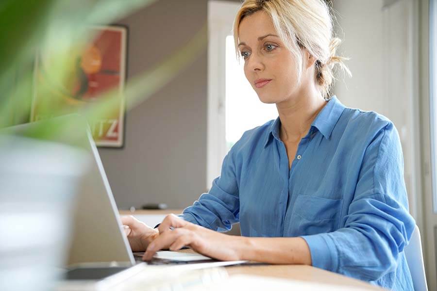 A woman does research on her laptop about how to open a traditional IRA.