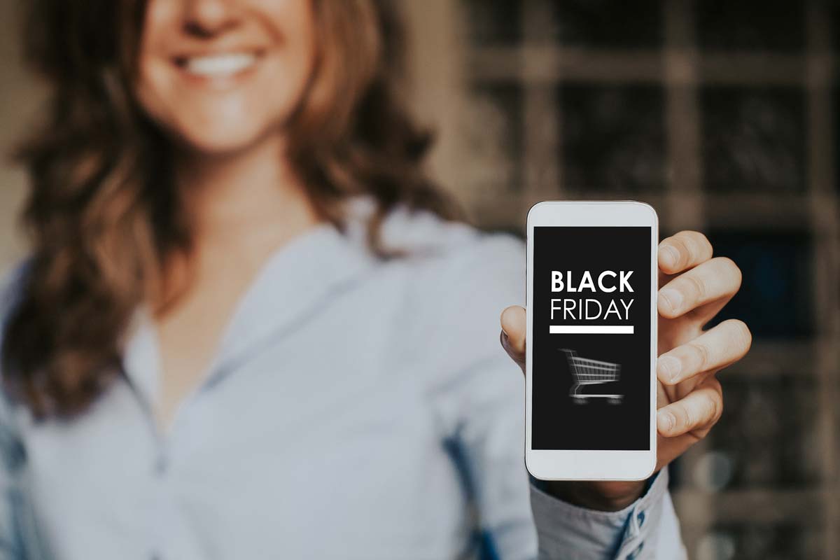 Woman holding cell phone that shows Black Friday deal screen