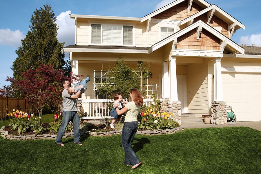 A family playing in the yard of the home they leveraged to refinance a home equity loan.