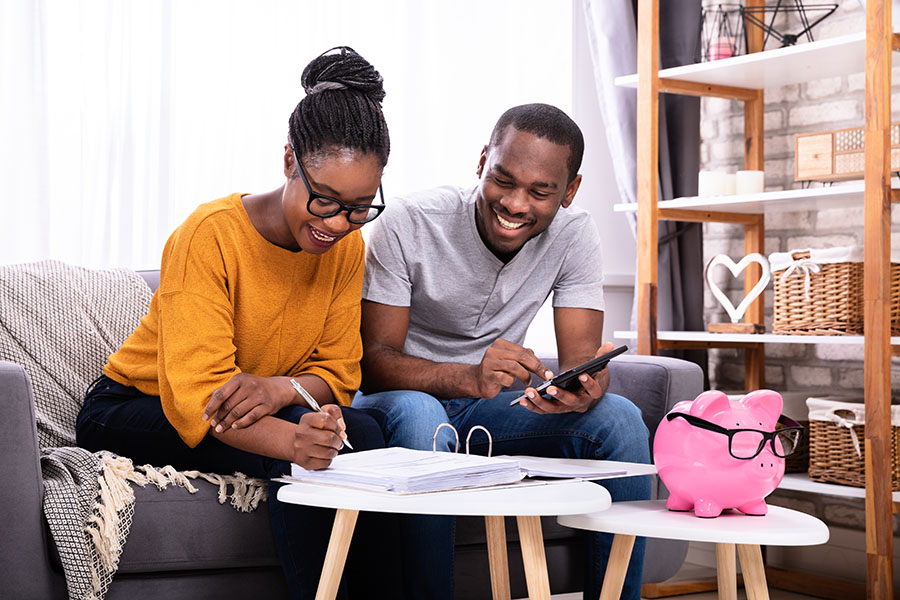 A happy couple is looking at their statements and thinking about checking accounts vs savings accounts.