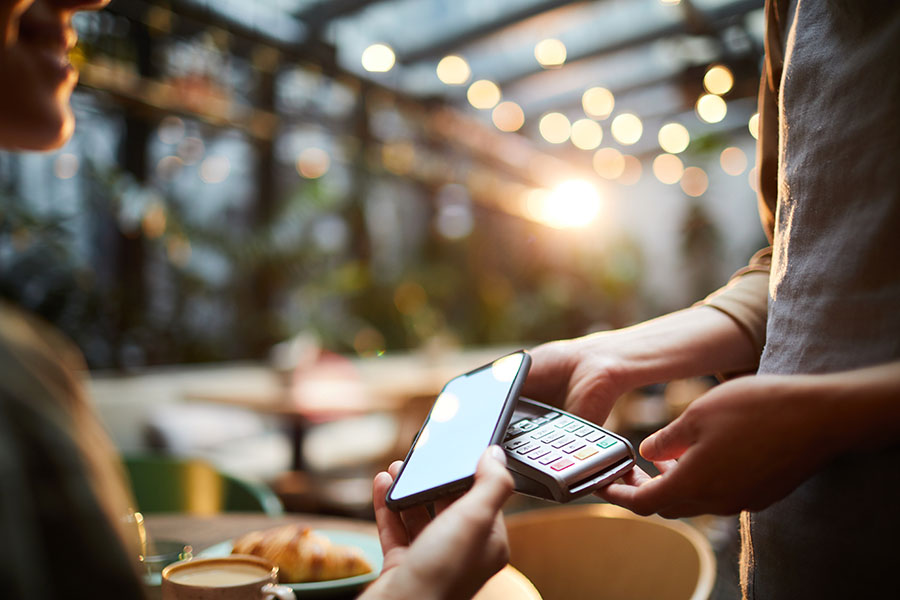 A person is using their phone and checking account to pay for a meal.