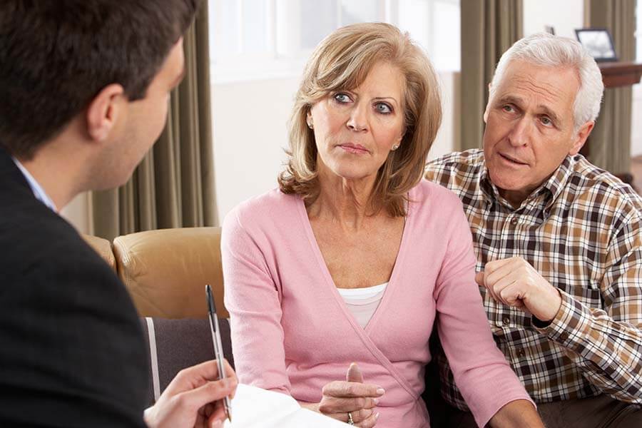 An older couple discusses the rules of an inherited IRA with a financial advisor.