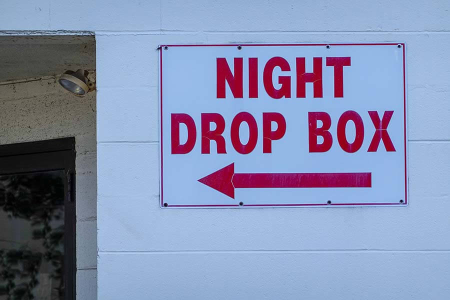 A sign pointing to a Night Drop Box for loan payments.