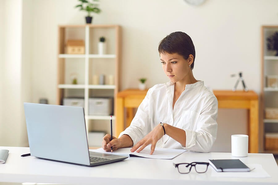 A young woman on her laptopresearching how to open a money market account.