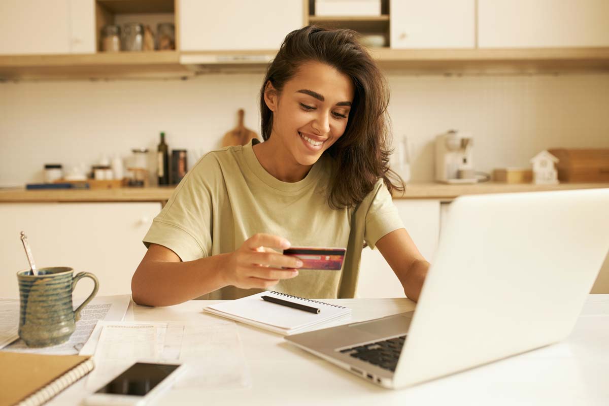 Woman using her credit card for an online purchase on her laptop