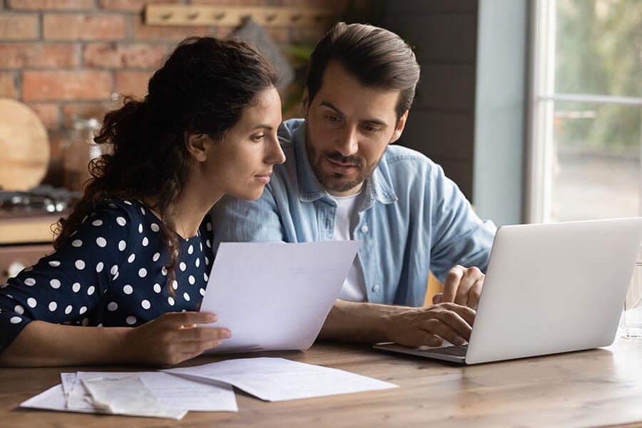 A young couple does research on their laptop about requirements for home equity loans.