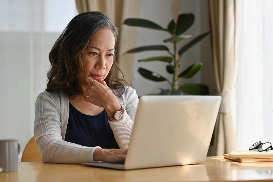 A woman does online research about how to use a Roth IRA as an emergency fund.