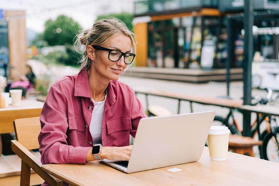 A woman does research on her laptop about the pros and cons of certificates of deposit.