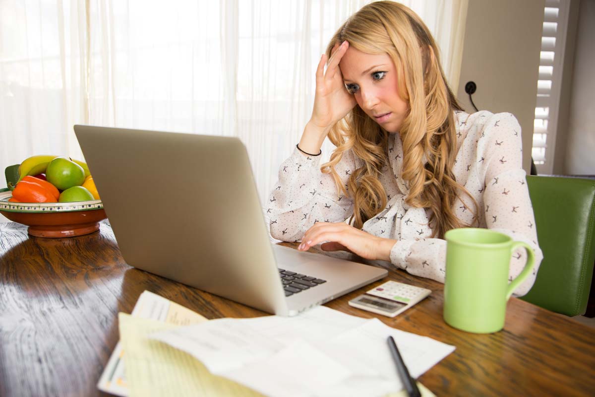 Woman looking upset at laptop screen