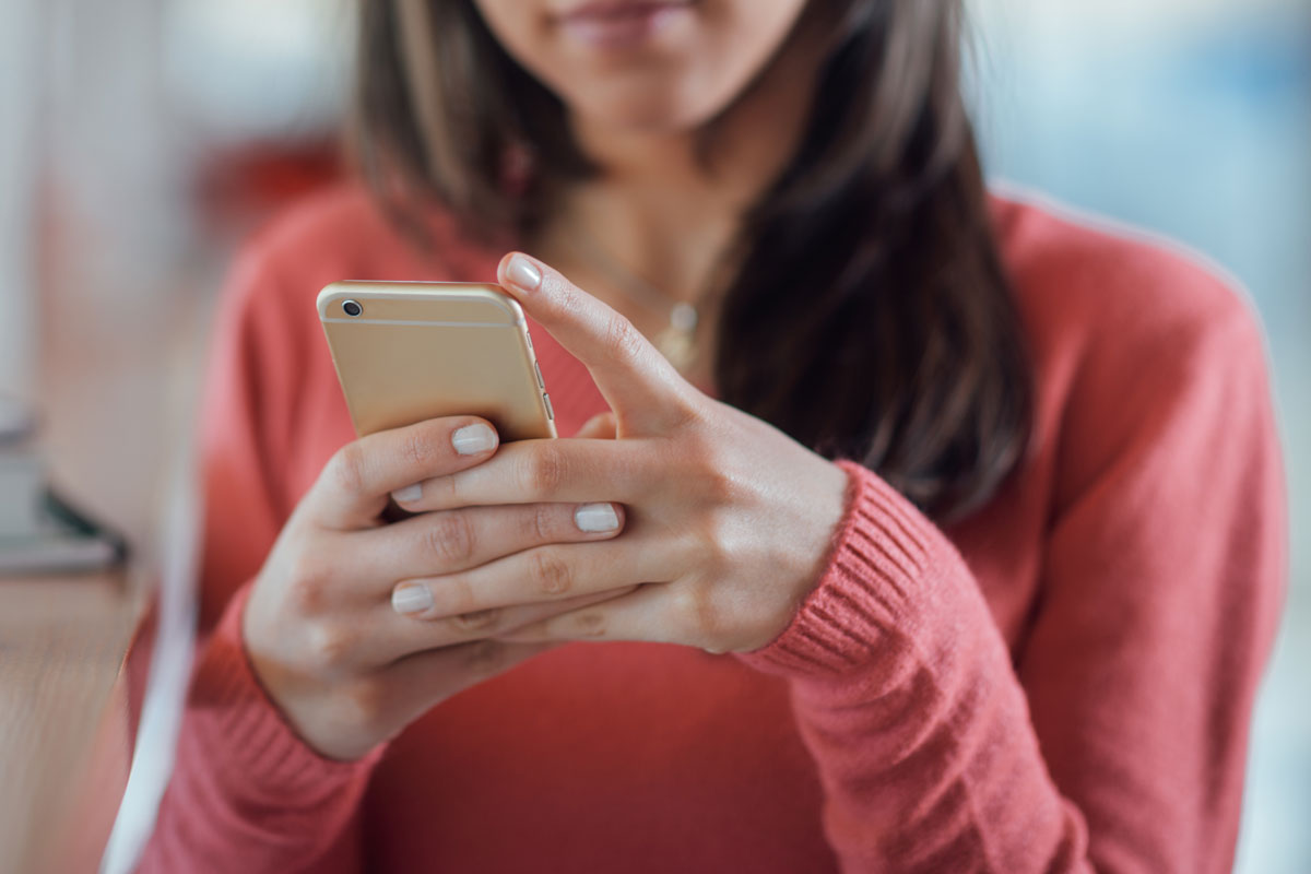 woman looking at cellphone in hands