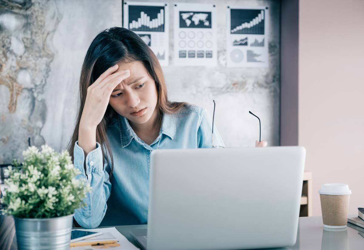 Thoughtful woman looking at a laptop