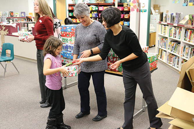 Passing out shoes to a little girl