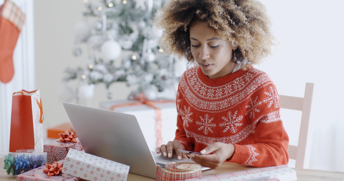 woman shopping on laptop and paying with card