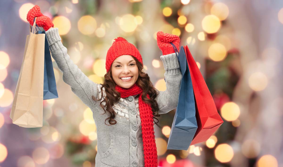 woman holding up holiday shopping bags
