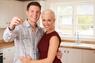 Happy couple holding keys to new house