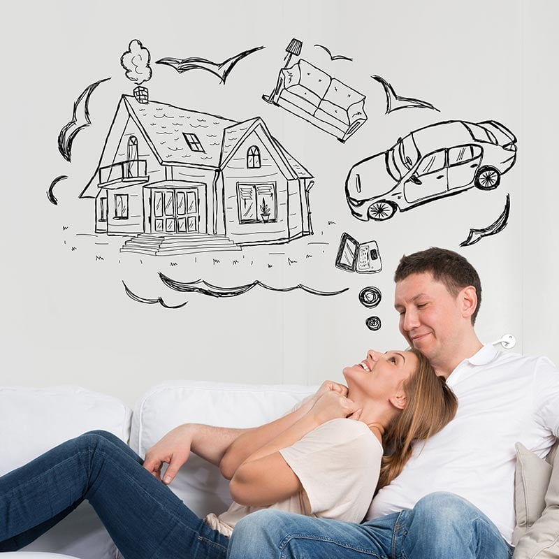 Couple sitting on couch with thought bubble of house, couch, laptop, and car