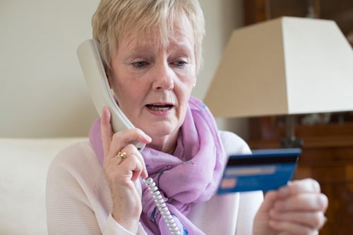 Older woman giving credit card number over the phone