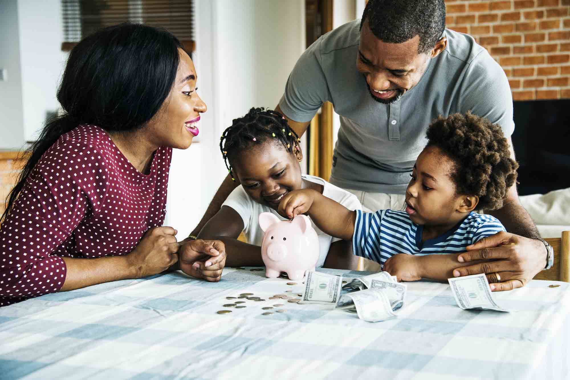 Family putting money into a piggy bank