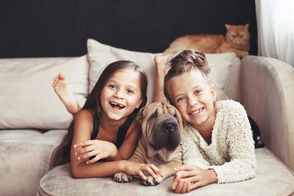 Girls laying with dog in the middle