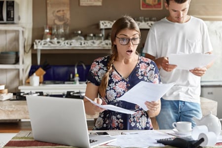 Woman looking at bills surprised