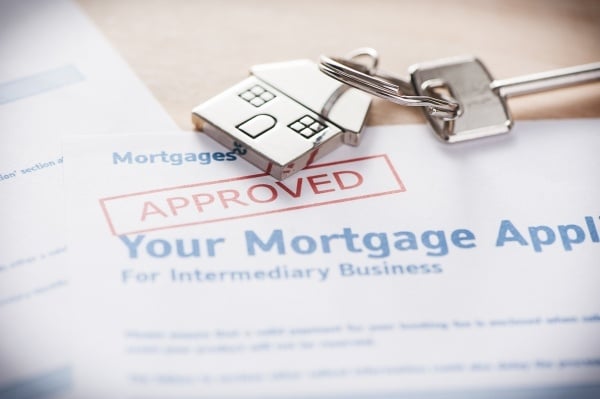 House key on top of Approved Mortgage Application