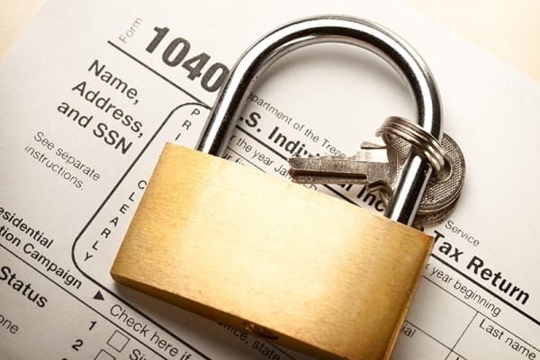 Tax Form 1040 with a secured lock on top of it