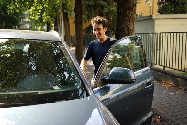 Young man getting into car