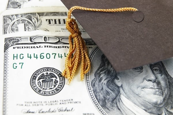 Graduate cap on top of $100 dollar bill