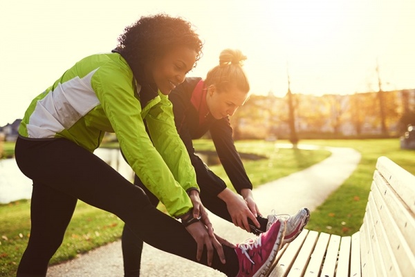 Two women stretching before running