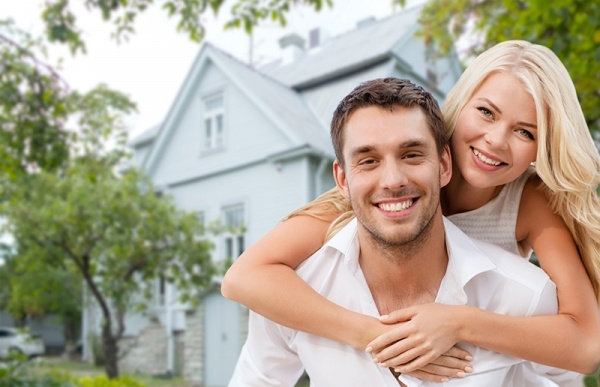 Smiling couple in front of a house