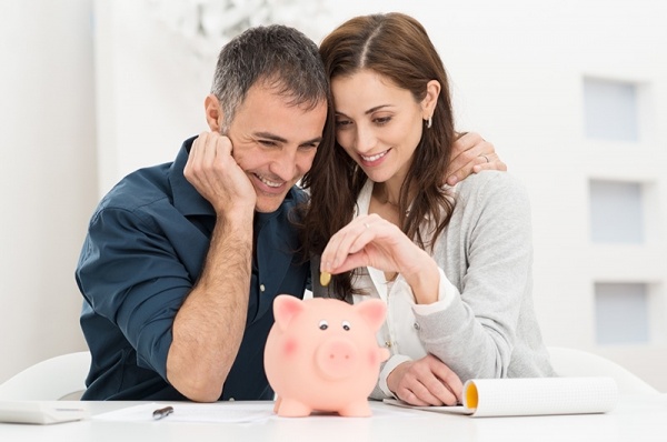 Couple putting money in piggy bank