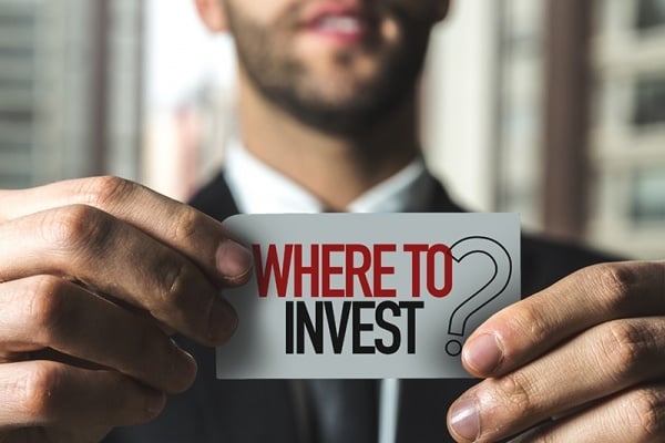 Man holding Where to Invest sign