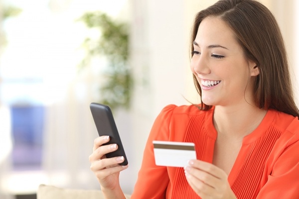 Women holding card and looking at cell phone